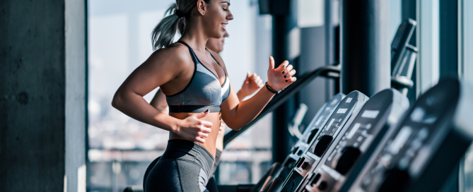 Women running on treadmills in a gym, showcasing fitness and training performance.